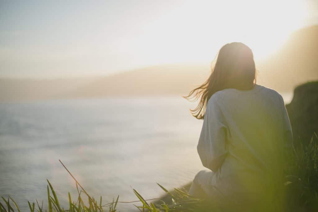 Woman pictured from behind, with ocean in background